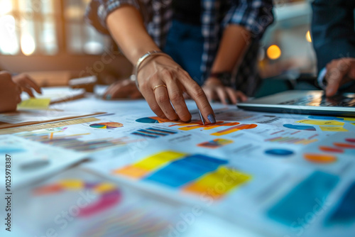 Closeup of an economic strategy session with hands over a table full of graphs on fiscal policy sector innovation and sustainability