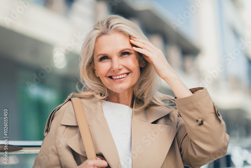 Portrait of attractive senior dreamy female resting walking strolling enjoy weekend touch hair wear beige coat pastime fresh air outdoor