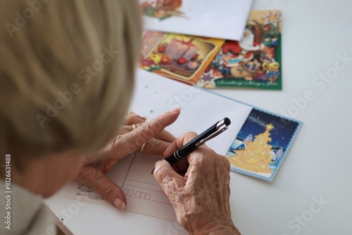 An elderly woman writing Christmas cards