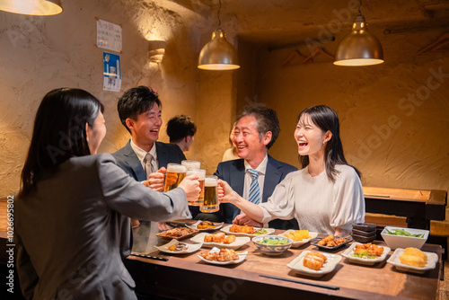 居酒屋で乾杯をする男女のビジネスパーソン