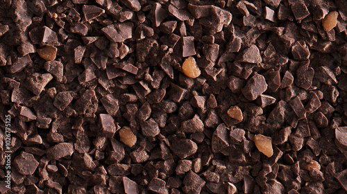 a close-up, top-down view of chopped ginger-flavored chocolate, with dark brown chocolate pieces intermixed with tiny bits of crystallized ginger