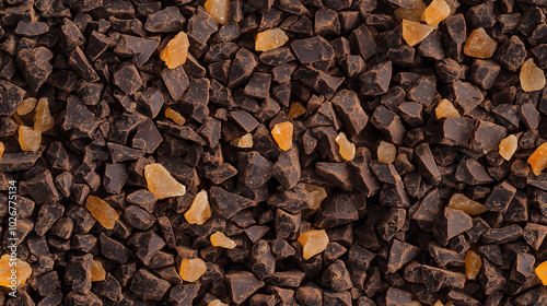 a close-up, top-down view of chopped ginger-flavored chocolate, with dark brown chocolate pieces intermixed with tiny bits of crystallized ginger