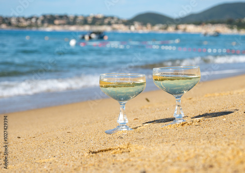 Summer time on French Riviera, two coupe glasses of champagne cremant sparkling wine on Pampelonne sandy beach near Saint-Tropez in sunny day, Var, vacation in France