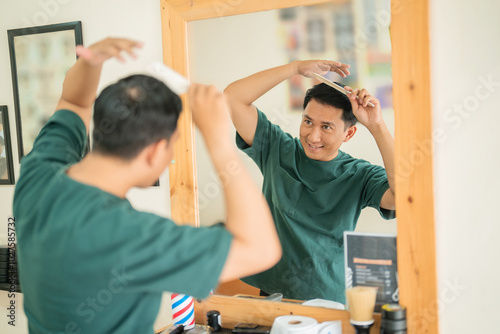 A man is carefully brushing his hair while standing in front of a mirror, taking his time to make sure he looks presentable and tidy