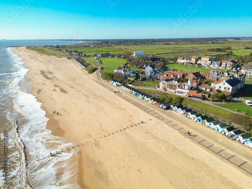 Wonderful aerial image of the famous Southwold, Suffolk, UK coastline in early autumn. The long row of famous wooden beach huts can be seen overlooking the golden beach.