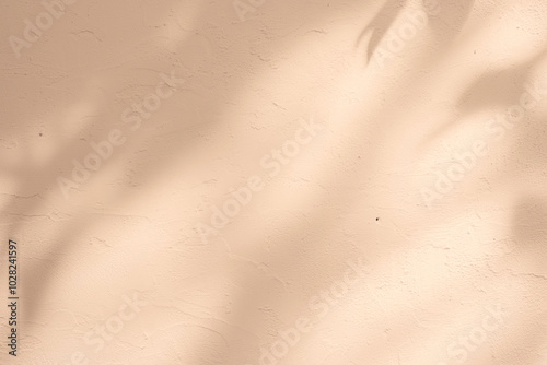 Empty beige background with sunlight superimposed shadow leaves on the wall. autumn background template for product presentation concept