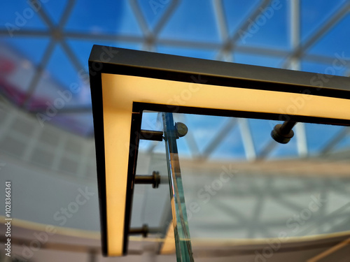 from the bottom of the handle is a recessed LED strip with a yellow light. the side of the stair railing is made of glued glass panels without frames. stainless steel railing bars on metal corner