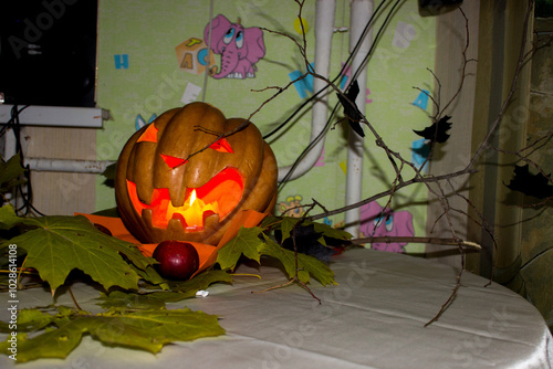 pumpkin with prose lights up on Halloween, branch, candles, autumn leaves, decoration, party, holiday, children's center