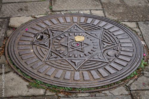 old antique cover, manhole manhole in the city on the sidewalk.