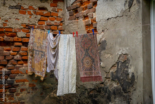 interior of a tenement house, yard in an abandoned, neglected and ruined tenement house in the city center. shabby walls of tenement houses. hanging old rags, rugs and clothes on a line and a clothes 