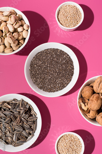 Semillas de chía, sésamo, pipas de girasol, nueces y pistachos. Frutos secos sobre un fondo rosa. Vista superior 