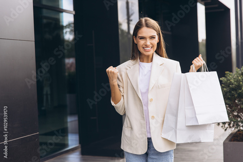 Joyful Woman Holding Shopping Bags Outside Modern Store