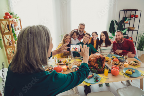 Photo of charming happy big family celebrating thanksgiving day woman photographing friendly family indoors room home