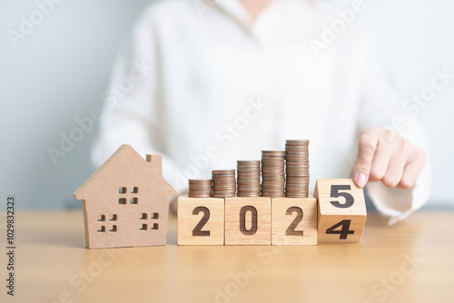 2024 end year to Happy New Year 2025 with house model and Coins stack. real estate, Home loan, tax, investment, mortgage, financial, savings and New Year Resolution concepts