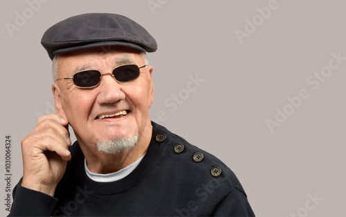 portrait homme âgé avec casquette sur fond gris