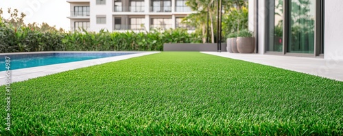 Lush green artificial grass lawn beside a modern pool, creating an inviting outdoor space.