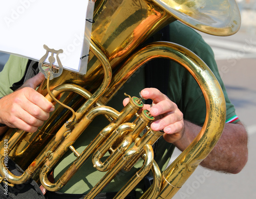 trombone player playing a melody by moving his fingers on the brass instrument