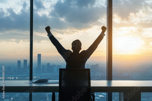 Businessperson raising arms in victory after closing a major deal.