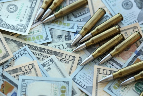 Yellow cartridges and bullets on dollar bills