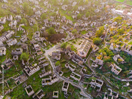 Aerial view of abandoned ancient Greek village of Kayakoy overlooking remaining houses covering green mountainside, Turkey