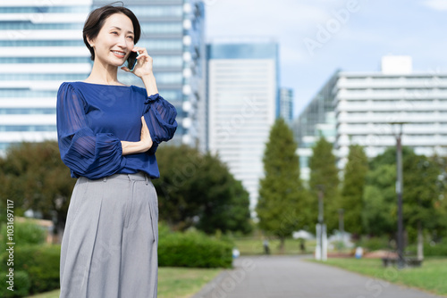 ビル街で通話をしている女性