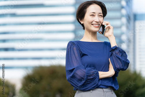 ビル街で通話をしている女性