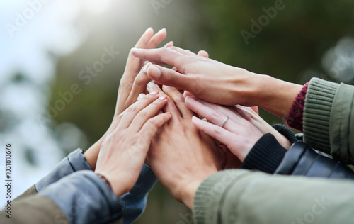 People, group and hands together with community for unity, motivation or mission in nature. Closeup, huddle or team piling or touching for collaboration, coordination or solidarity at outdoor park