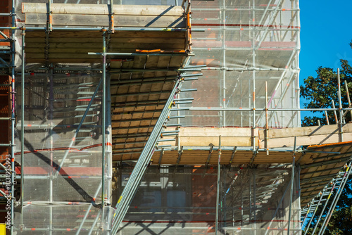 Scaffold sheeting net wrapped apartments building during insulation in england uk