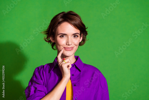 Portrait photo of young intelligent young cute lady in purple shirt touch chin cunning thinking isolated on green color background