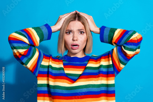 Photo of nice young woman hands touch head wear striped sweater isolated on blue color background