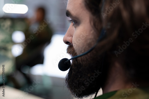 Army recruit working on reconnaissance mission to gather intelligence, operating with global satellite system for surveillance. IT operator working in military headquarters power base. Close up.