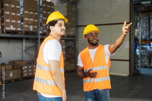 Diverse foreign workers standing at warehouse and taking about logistic and gesturing.