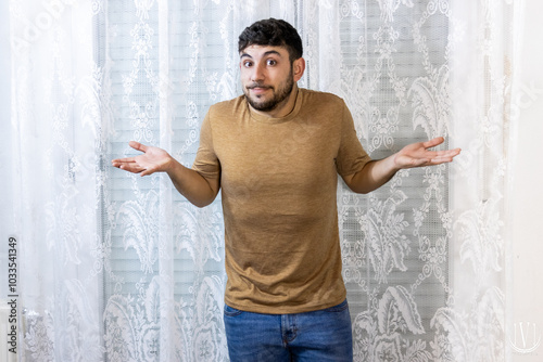 Man shrugging with arms raised on a white background