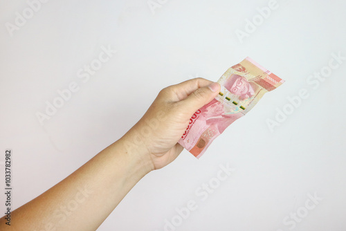 Man's Hand holding rupiah money isolates on white background