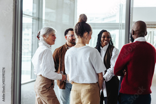 Diverse business colleagues engaging in conversation during a conference in a modern office setting