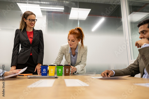 Business people discussing about recycling around meeting table