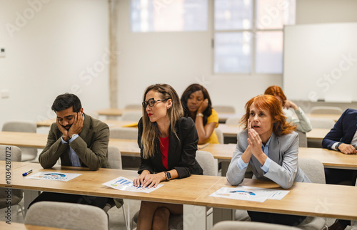 Bored business people sitting at desks during a business training