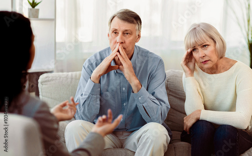 Marriage Therapy. Female psychologist consulting sad elderly couple, copyspace