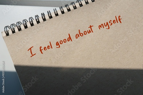 Brown notebook with handwritten text I FEEL GOOD ABOUT MYSELF - Positive affirmation to boost self confidence - overcome self-doubt and low self-esteem