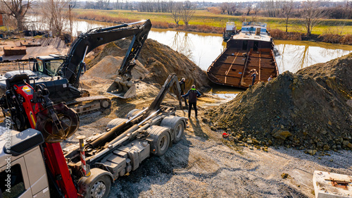 Aerial view on excavator and tow truck as they move part of vessel