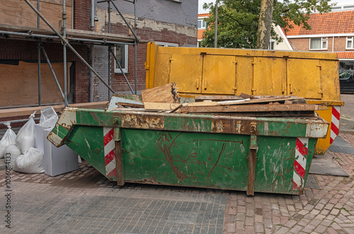 yellow and green industrial waste containers stand outside on the street