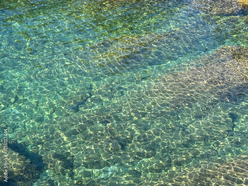 Beautiful sea water clear turquoise seascape with underwater stones and pebbles.