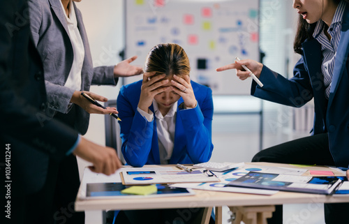 Businesswoman is feeling stressed while her coworkers are being aggressive and blaming her for something during a business meeting