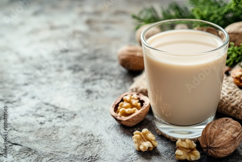 Walnut Milk. Organic Walnut Nuts and Glass of Vegan Walnut Milk on Stone Background