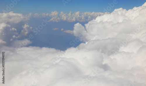 clouds below and the blue sky seen from an airplane during an intercontinental flight