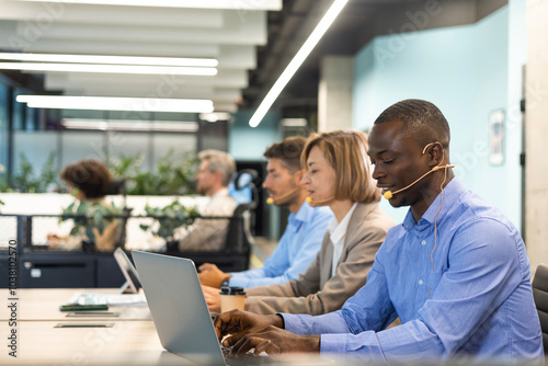 Happy young male customer support executive working in office.