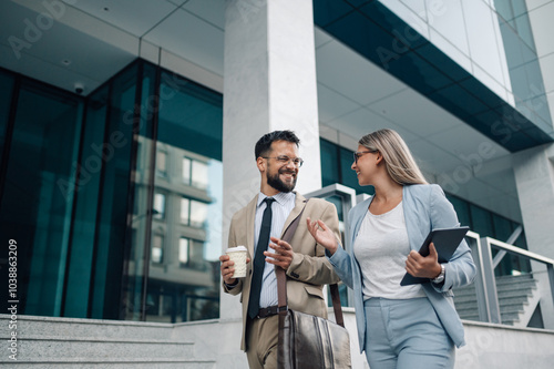 Business people walking and talking outside office building