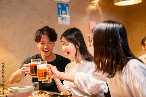 居酒屋でお酒を飲む若い男女