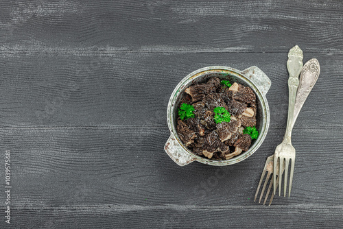 Raw black morel mushrooms with fresh parsley. Vegan ingredient for cooking healthy food