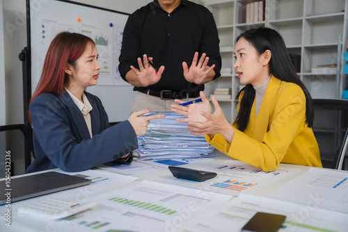 Office Conflict: Two businesswomen engage in a heated disagreement, while a male colleague attempts to mediate. The scene depicts workplace tension and the challenges of communication.